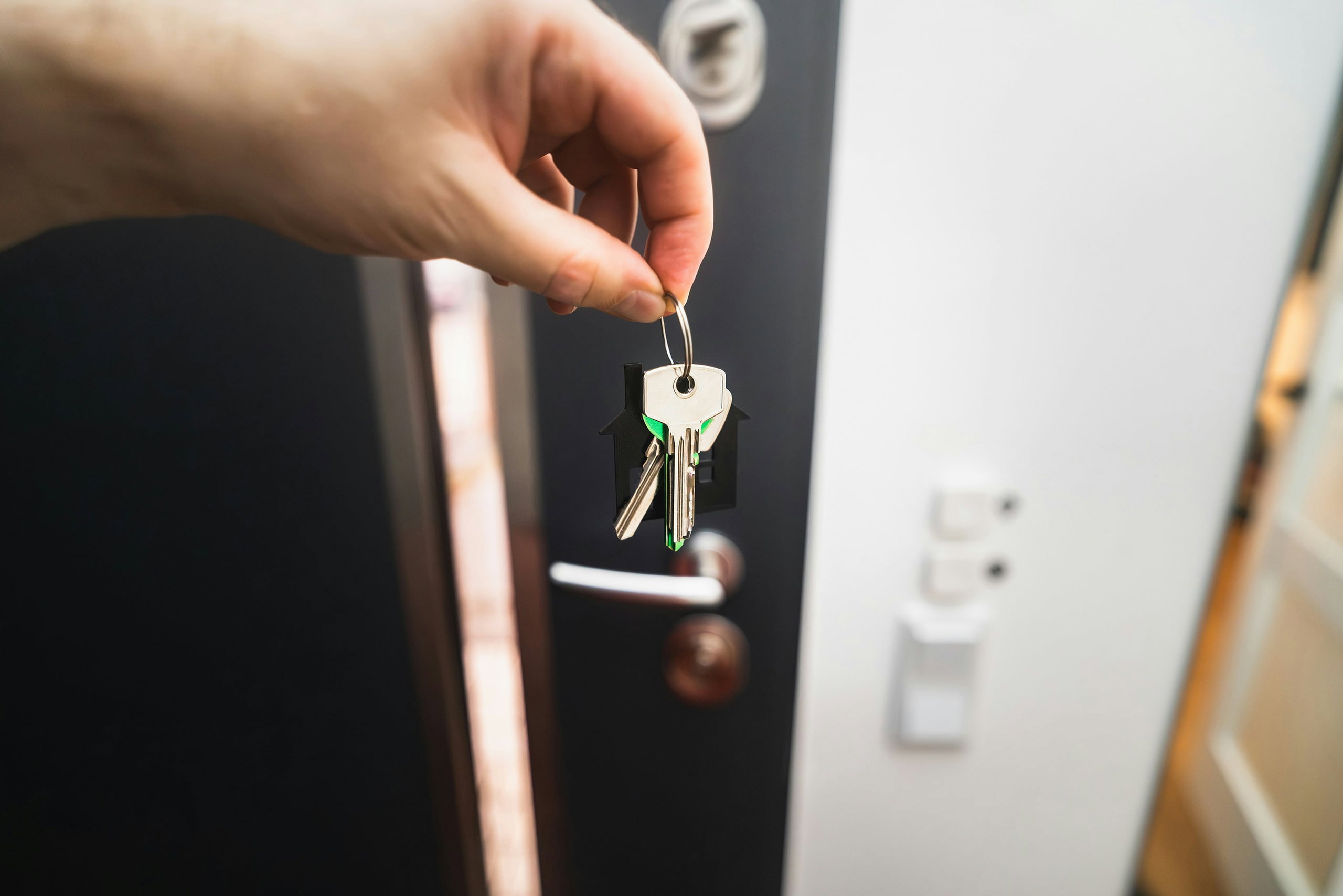 A person holding a key to a front door